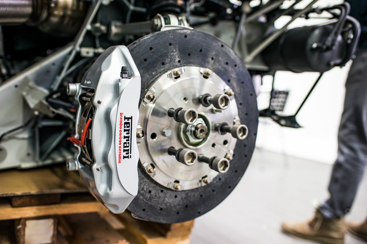 why-choose-us-01 Detailed view of disc brake and caliper on a high-performance car, emphasizing precision and technology.